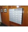 Agrupaciones de 26 buzones Milenio H4400-01, con envolvente de aluminio, colgados en la pared y bandeja de 2 anchuras