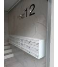 Agrupaciones de 18 buzones Infinity, de color Blanco, con envolvente de acero galvanizado color blanco y colgados en la pared