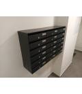 Agrupación de 18 buzones Adapta H3800-04, color Antracita. Con envolvente de acero galvanizado negro, colgados en la pared
