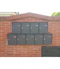 Agrupación de Joma, de 9 buzones Kompact v270-81120- Todo Negro con envolvente colgados en la pared en el exterior.