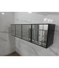 Agrupación de 16 buzones Prisma acceso sup. Grupo de 4. Negro / inox brillo. Colgados en la pared.